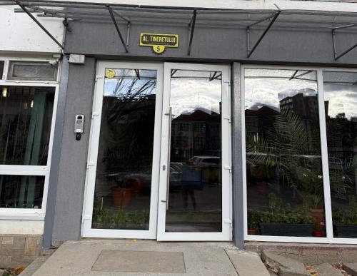 a store front with white doors and a sign on it at Victoria 1 Room Apartment- Self Check in 24h in Reşiţa