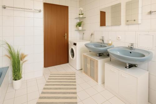 a bathroom with two sinks and a washing machine at SUNNYHOME Monteurwohnungen und Apartments in Schwandorf in Schwandorf in Bayern