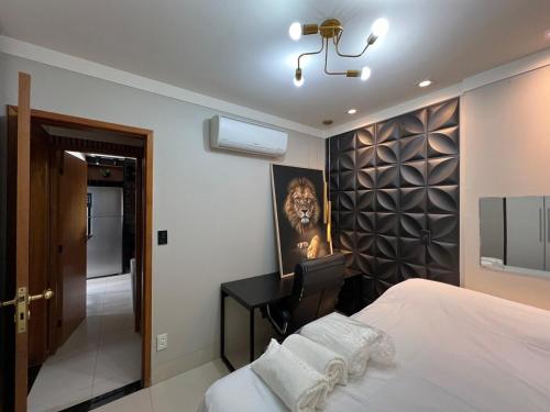 una camera da letto con un letto e una scrivania e una stanza di Ap Setor universitário a Goiânia