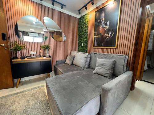 un soggiorno con un divano e uno specchio di Ap Setor universitário a Goiânia