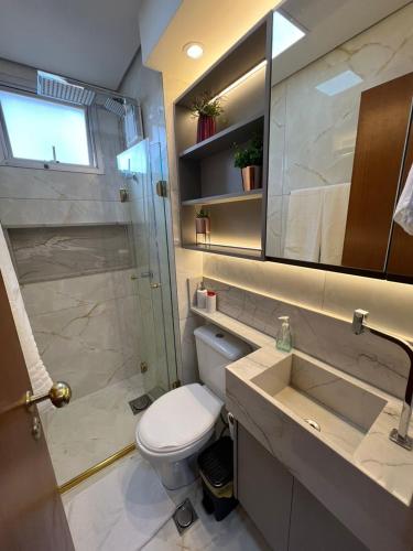 a bathroom with a toilet and a shower and a sink at Ap Setor universitário in Goiânia