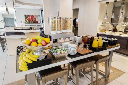a kitchen with a table with a bunch of fruit at Hilton Garden Inn New Braunfels in New Braunfels