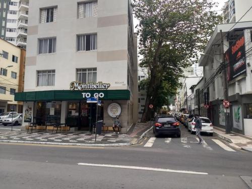 a street with cars parked in front of a building at Apartamento na praia in Balneário Camboriú