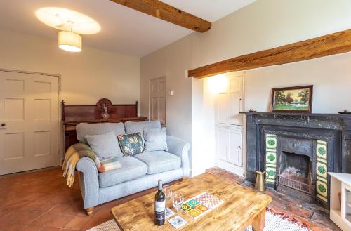 a living room with a couch and a fireplace at Prince Rupert's cottage with garden in Sibbertoft