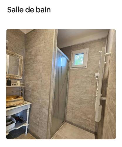 a bathroom with a shower with a glass shower stall at Maison détente in Nonant