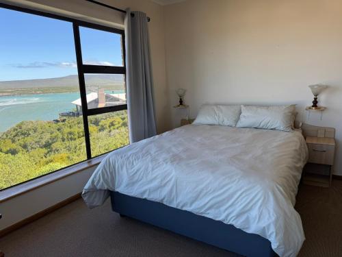 a bedroom with a bed and a large window at Amia in Witsand