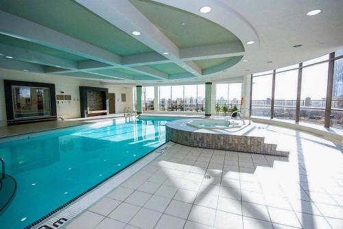 a large swimming pool in a building with windows at PlanURstay - Amazing 2BR & 2BTH - Near Square One Mall in Mississauga