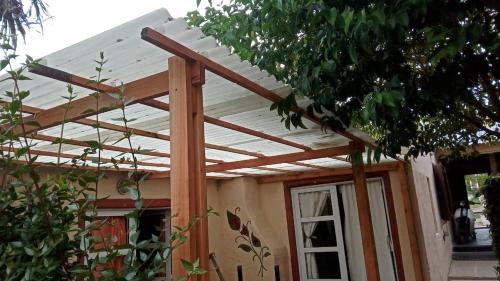 een houten pergola boven de deur van een huis bij Casa de Olga in Tandil