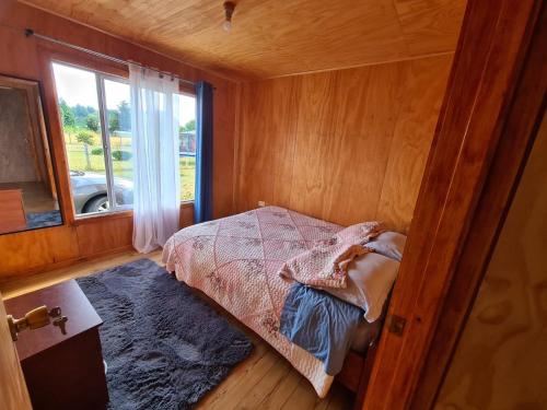 a bedroom with a bed in a room with a window at Cabaña Pueblo Hundido in Futrono
