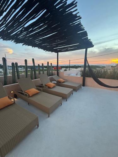 a group of chairs sitting on top of a roof at Casa Kensho Sisal in Sisal