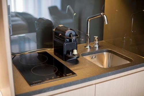 a kitchen counter with a mixer and a sink at Ilonn Boutique Limanowskiego in Poznań