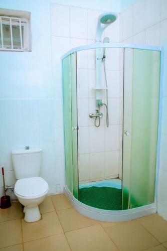 a bathroom with a toilet and a glass shower at Zebra Domus in Huye