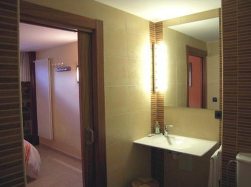 een badkamer met een wastafel en een spiegel bij Casa Rural Apartamento El Chaveto in Herreros