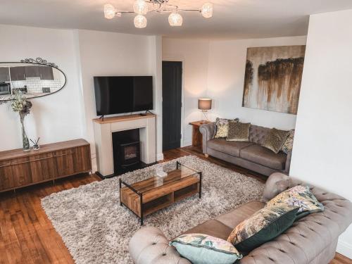 a living room with a couch and a tv at Charming 2-Bed House by Brookland Stays in Jersey Free Wi-Fi & Parking Included 