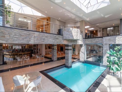 an indoor swimming pool in a house with a glass ceiling at Silva Villa in Bedfordview