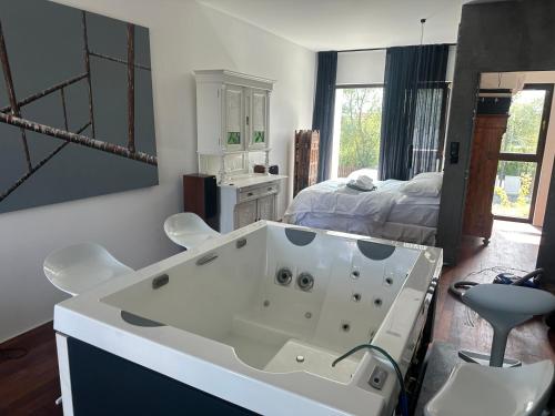 una gran bañera blanca en una habitación con cama en Baltic Riviera, en Wiślinka