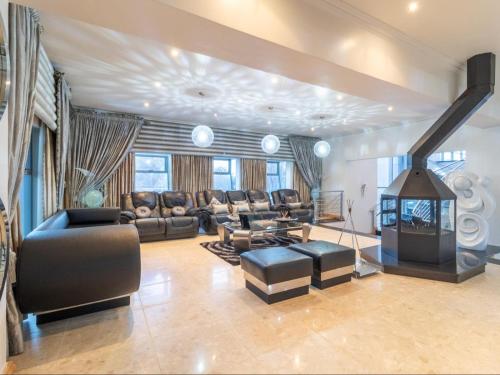 a living room with leather furniture and a fireplace at Silva Villa in Bedfordview