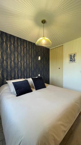 - un grand lit blanc dans une chambre avec plafond dans l'établissement La maison d a cote, à Éguzon-Chantôme