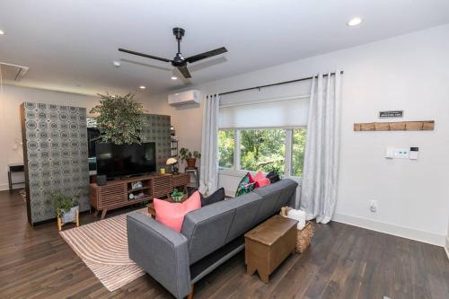 a living room with a gray couch and a television at Skyline Views, Mins To Downtown in Atlanta