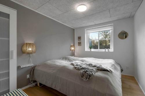 een slaapkamer met een groot bed met een raam bij C11690-Hemmet-Lukkebjerg-7 in Falen