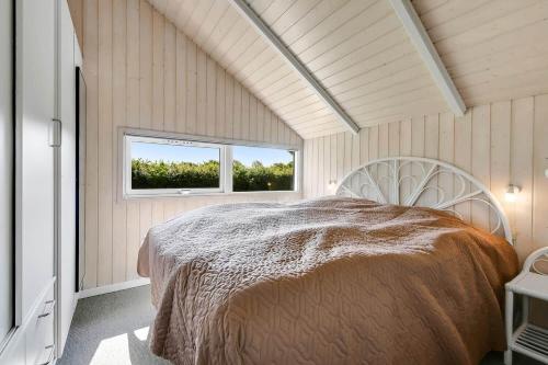 a bedroom with a bed in a room with a window at C11725-Hemmet-Strandvaenget-23 in Falen