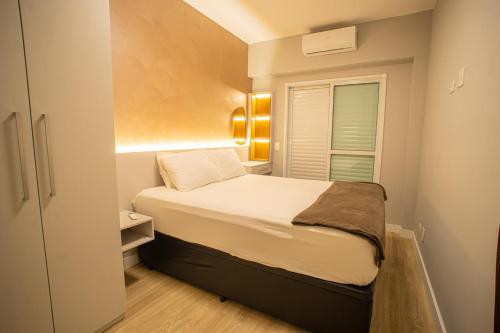 Vila BalneáriaにあるApto com Ar-condicionado e Churrasqueira Privativaのベッドと窓のある小さな寝室