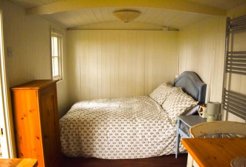 1 dormitorio con 1 cama en una habitación pequeña en Shepherd Hut in the woods, 
