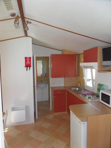 a small kitchen with red cabinets and a sink at Altogold Swiss Holidays At Manor Farm 5* in Interlaken