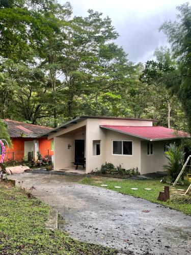 a small white house with a red roof at Cabaña con fogata BBQ y ríos cerro azul in Los Altos de Cerro Azul