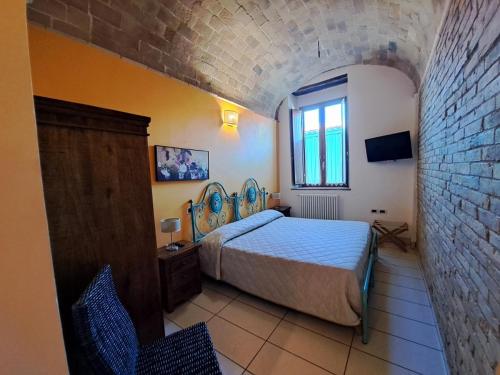 a bedroom with a bed and a brick wall at La Casa Del Palombaro in Ortona