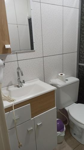 a bathroom with a sink and a toilet and a mirror at Chalé Paraíso Da Serra 02 in Gramado