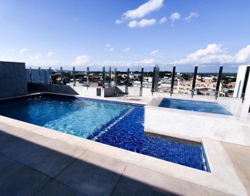 a swimming pool on the roof of a building at Good Stone Curvelo Hotel in Curvelo
