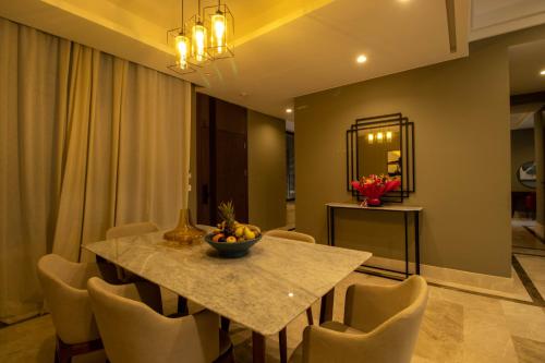 マラケシュにあるM Résidence Marrakech Luxury Serviced Apartmentsのダイニングルームテーブル(椅子付)、フルーツボウル