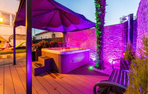 a hot tub sitting under an umbrella on a patio at Cozy Apartment In Sukosan in Sukošan