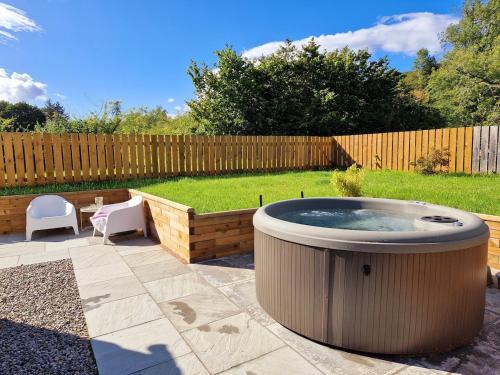 einen Whirlpool inmitten eines Gartens in der Unterkunft Highland River Cottage with Hot Tub in Evanton