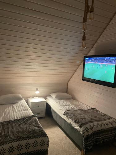 a bedroom with two beds and a flat screen tv at Witam Karpacz 2 in Karpacz