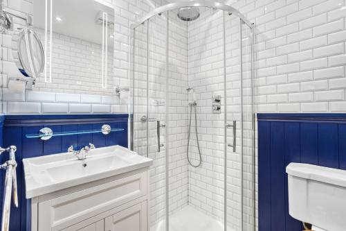 a white bathroom with a sink and a shower at 9 At The Beach, Torcross in Torcross