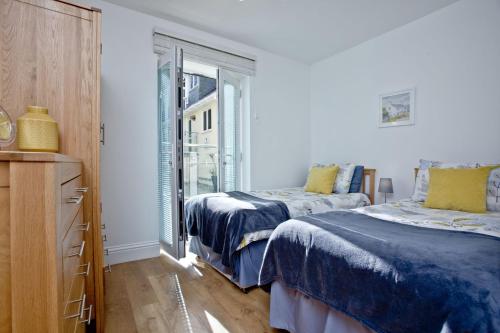 a bedroom with two beds and a window at 9 At The Beach, Torcross in Torcross