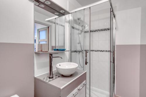 Un baño blanco con lavabo y ducha. en Le Confort du Soir - T2 - Lagnieu, en Lagnieu