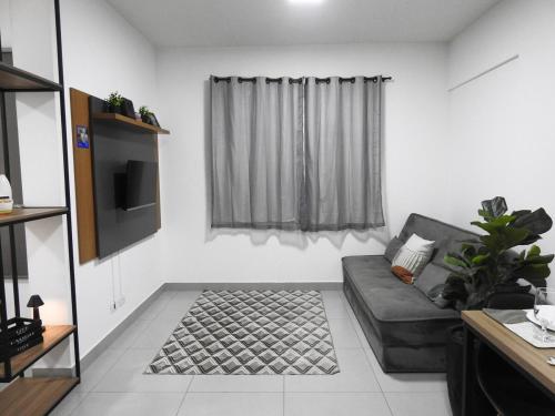 a living room with a couch and a tv at Seu Refúgio Confortável e Moderno em Foz do Iguaçu in Foz do Iguaçu