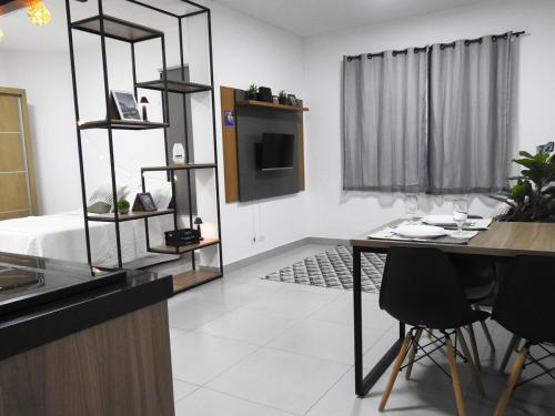 a kitchen with a table and a television in a room at Seu Refúgio Confortável e Moderno em Foz do Iguaçu in Foz do Iguaçu