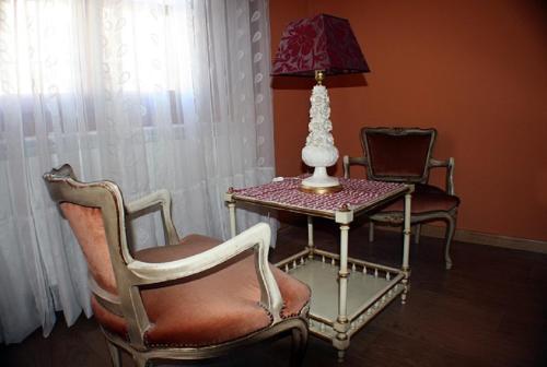 a room with two chairs and a table with a lamp at La Casa del Reloj in Enciso