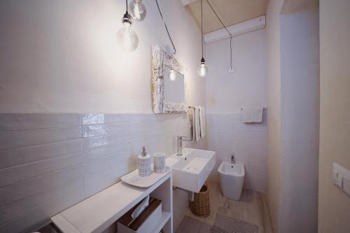 a white bathroom with a sink and a toilet at Borgo Lianti case vacanza Sardegna in San Pasquale