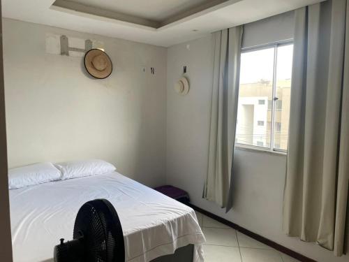 um quarto branco com uma cama e uma janela em Apartamento aconchegante próximo a praia em Ilhéus