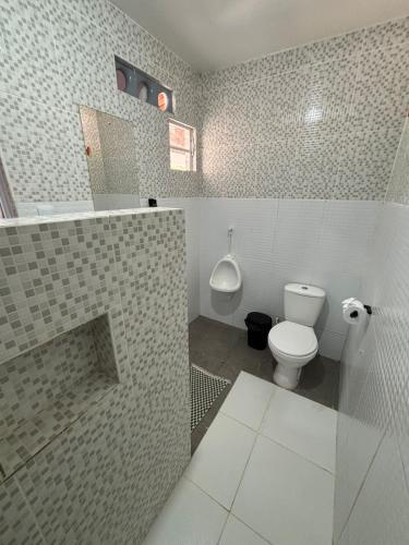 a bathroom with a white toilet and a sink at Summer House in Jijoca de Jericoacoara