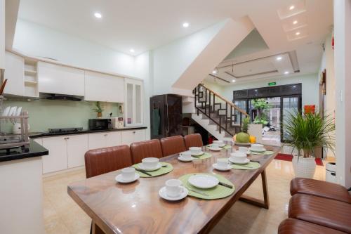 a kitchen and dining room with a wooden table and chairs at AnhHouse85 Da Nang - 750 meters from the beach - Free airport pick up and free modern coffee machine provided in Da Nang