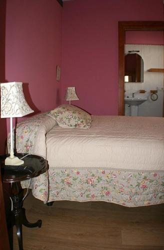 a bedroom with a bed with two lamps on tables at La Casa del Reloj in Enciso