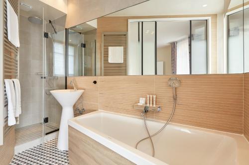 a bathroom with a tub and a sink at Hôtel de Sévigné in Paris