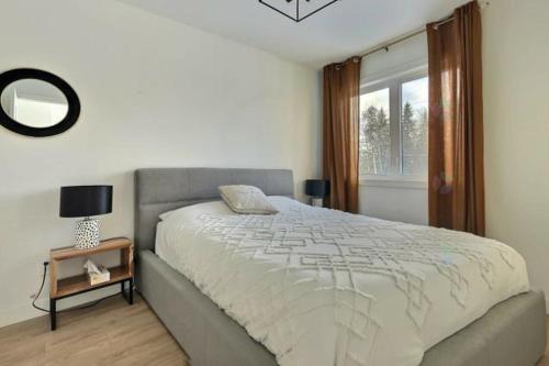 a bedroom with a large bed and a window at Chalet Athena in Pont-Rouge