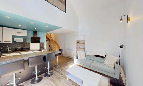 a kitchen and living room with a couch and a table at Maison cosy à 2 pas de la mer - Séjour à deux in Luc-sur-Mer